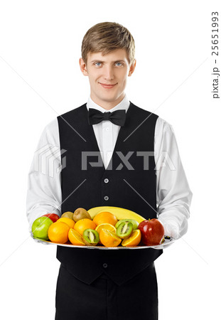 Young handsome waiter holding big tray full of fresh fruits Young handsome waiter holding big tray full of fresh fruits 25651993