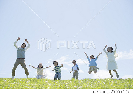 草原でジャンプをする小学生と先生 25655577