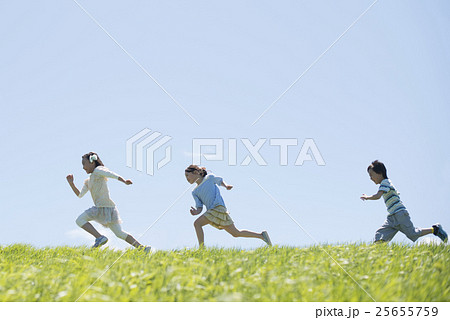 草原を走る小学生の写真素材