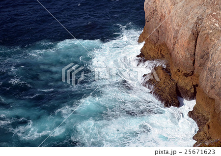 strong waves in blue sea splashing on rocks 25671623