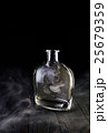 Empty decanter with smoke on black background 25679359