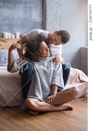 Young couple sitting together in a bedroom Young couple sitting together in a bedroom 25679777