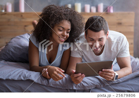 Happy couple watching their wedding photos on a Happy couple watching their wedding photos on a 25679806