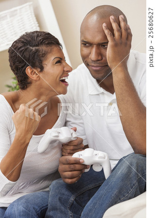 African American Couple Playing Video Console Game African American Couple Playing Video Console Game 25680627