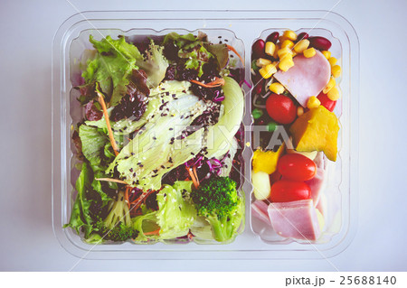 Fresh salad in packaging on white paper background Fresh salad in packaging on white paper background 25688140