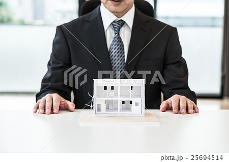 住宅模型とスーツ姿のビジネス男性 25694514