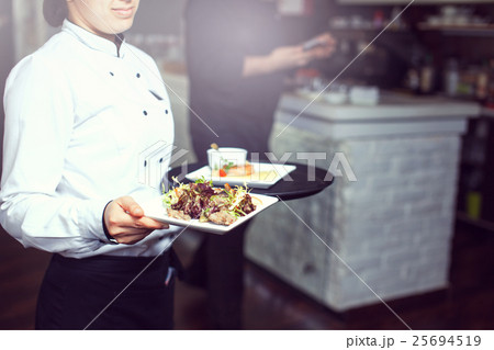 Waiters carrying plates with 25694519