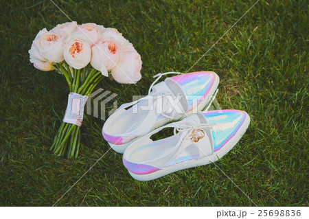wedding bouquet and shoes lying down on green wedding bouquet and shoes lying down on green 25698836
