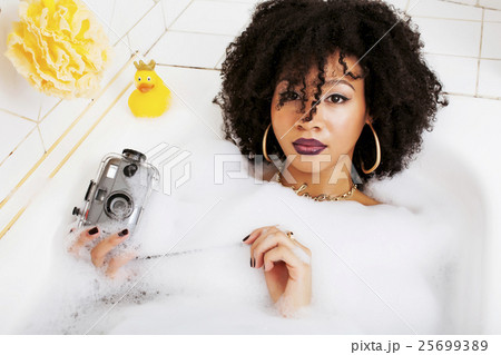 young afro-american teen girl laying in bath with 25699389