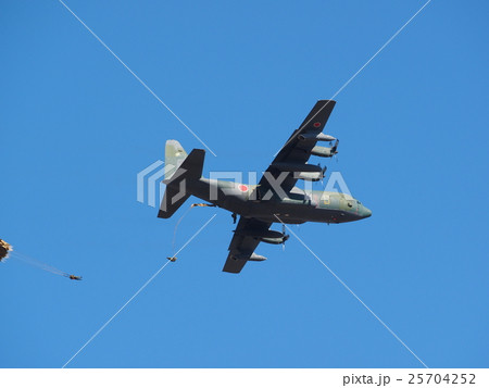 千葉県船橋市の習志野駐屯地で新春に行われる降下訓練始めで青空を飛行する輸送機と落下する落下傘 25704252