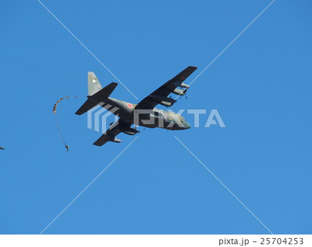 千葉県船橋市の習志野駐屯地で新春に行われる降下訓練始めで青空を飛行する輸送機と落下する落下傘 25704253