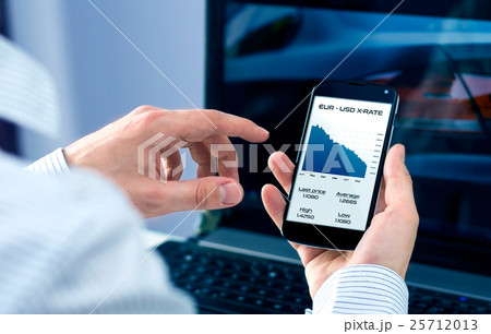 Businessman checks exchange rate on smartphone Businessman checks exchange rate on smartphone 25712013