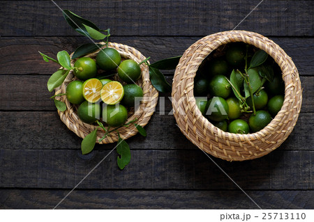 Green Kumquat fruit on wooden background Green Kumquat fruit on wooden background 25713110