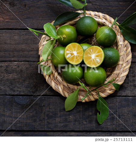 Green Kumquat fruit on wooden background Green Kumquat fruit on wooden background 25713111