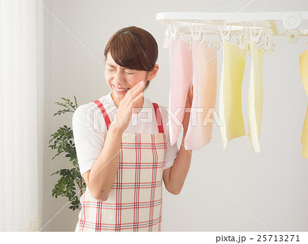 室内干しした洗濯物が臭くて顔を背ける女性の写真素材