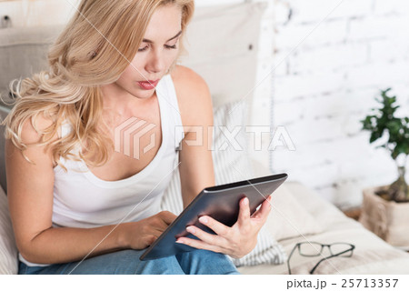 Blond woman using tablet at home 25713357