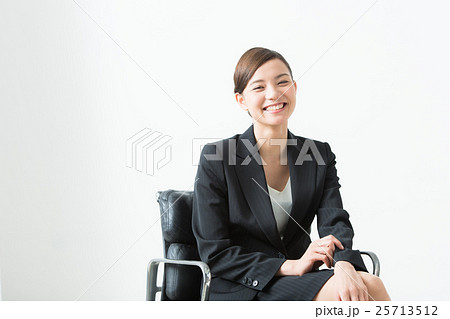 スーツ姿の女性 座る の写真素材