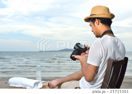 Young man looking at the camera on the beach Young man looking at the camera on the beach 25715301