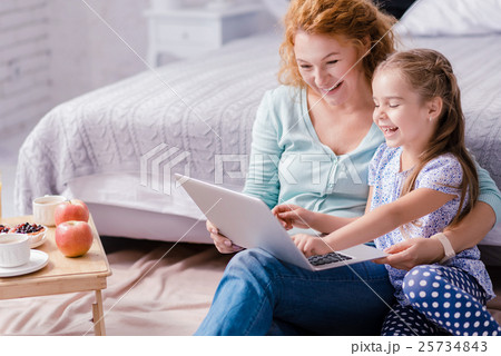 Girl sitting in front of the laptop with her 25734843