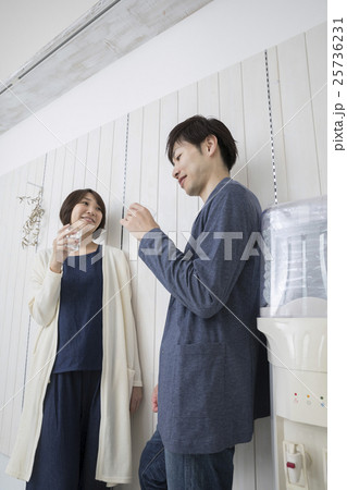ミネラルウォーターを飲みながら会話する夫婦 25736231