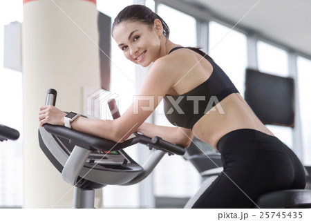 Smiling girl using treadmill in a gym 25745435