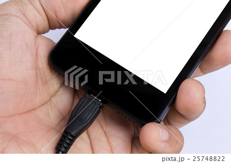 human's hand holding smart phone is charging 25748822