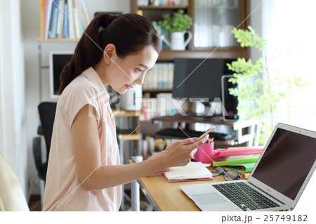 自宅でwebの仕事をする女性の写真素材