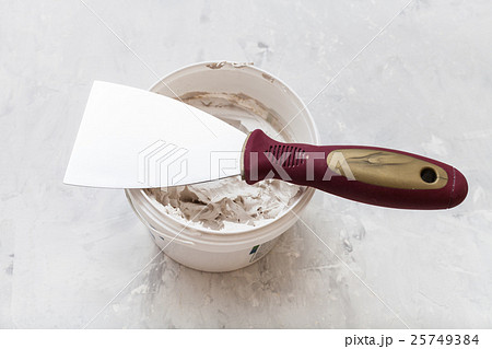 metal spatula on tube with putty 25749384