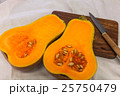 Squash cut in half on a wooden board 25750479