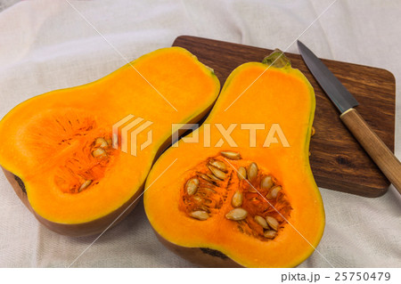 Squash cut in half on a wooden board 25750479