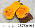 Squash cut in half on a wooden board 25750494