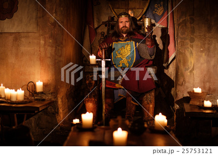 Medieval king on throne in ancient castle interior 25753121