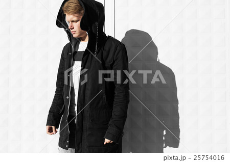 Young blonde man in autumn clothes standing near Young blonde man in autumn clothes standing near 25754016