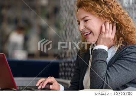 Side view of smiling woman using laptop Side view of smiling woman using laptop 25755700