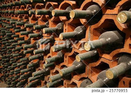 Racks with bottles in a dark wine cellar 25770955