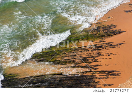 Rock formations on beach and surf wave. 25773277
