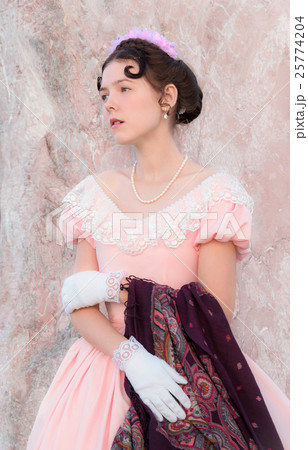 Romantic girl stands near a wall of pink stone 25774204