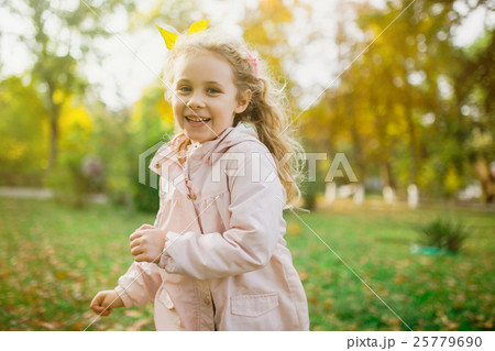 Happy child girl having fun in autumn park 25779690