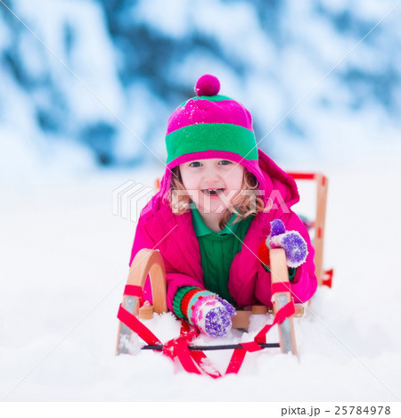 Little girl playing in snowy winter forest Little girl playing in snowy winter forest 25784978