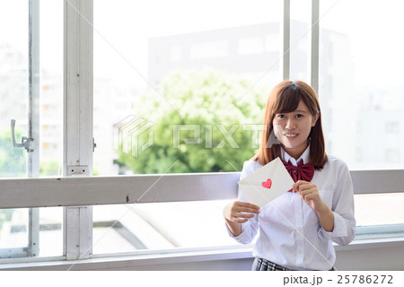 教室の窓でラブレターを持つ高校生 学生の写真素材