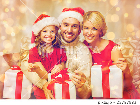 smiling family holding gift boxes and sparkles smiling family holding gift boxes and sparkles 25787933