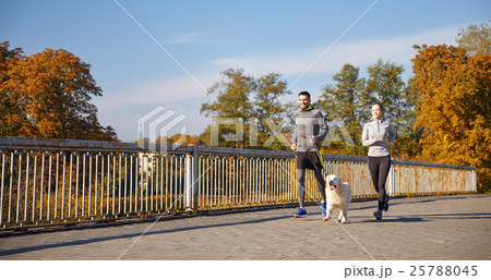 happy couple with dog running outdoors happy couple with dog running outdoors 25788045