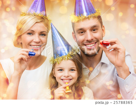 smiling family in blue hats blowing favor horns 25788365