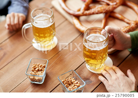 close up of hands with beer mugs at bar or pub close up of hands with beer mugs at bar or pub 25790005
