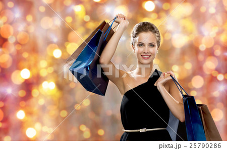 smiling woman in dress with shopping bags smiling woman in dress with shopping bags 25790286