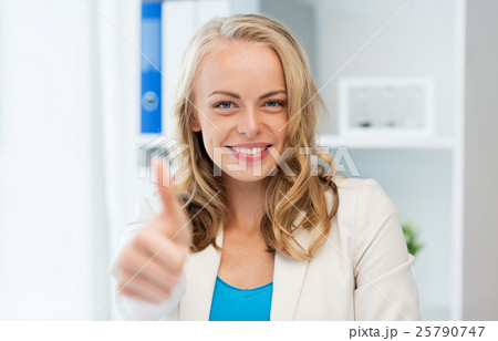 happy businesswoman showing thumbs up at office 25790747