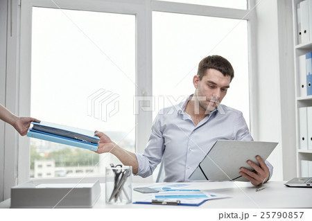 businessman taking papers from secretary in office 25790857