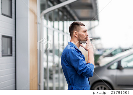 auto mechanic smoking cigarette at car workshop auto mechanic smoking cigarette at car workshop 25791502