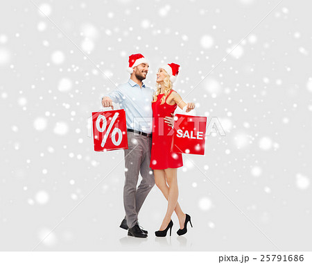 happy couple with red shopping bags over snow happy couple with red shopping bags over snow 25791686