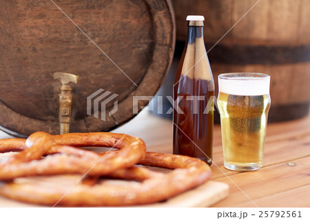 close up of beer barrel, glass, pretzel and bottle 25792561